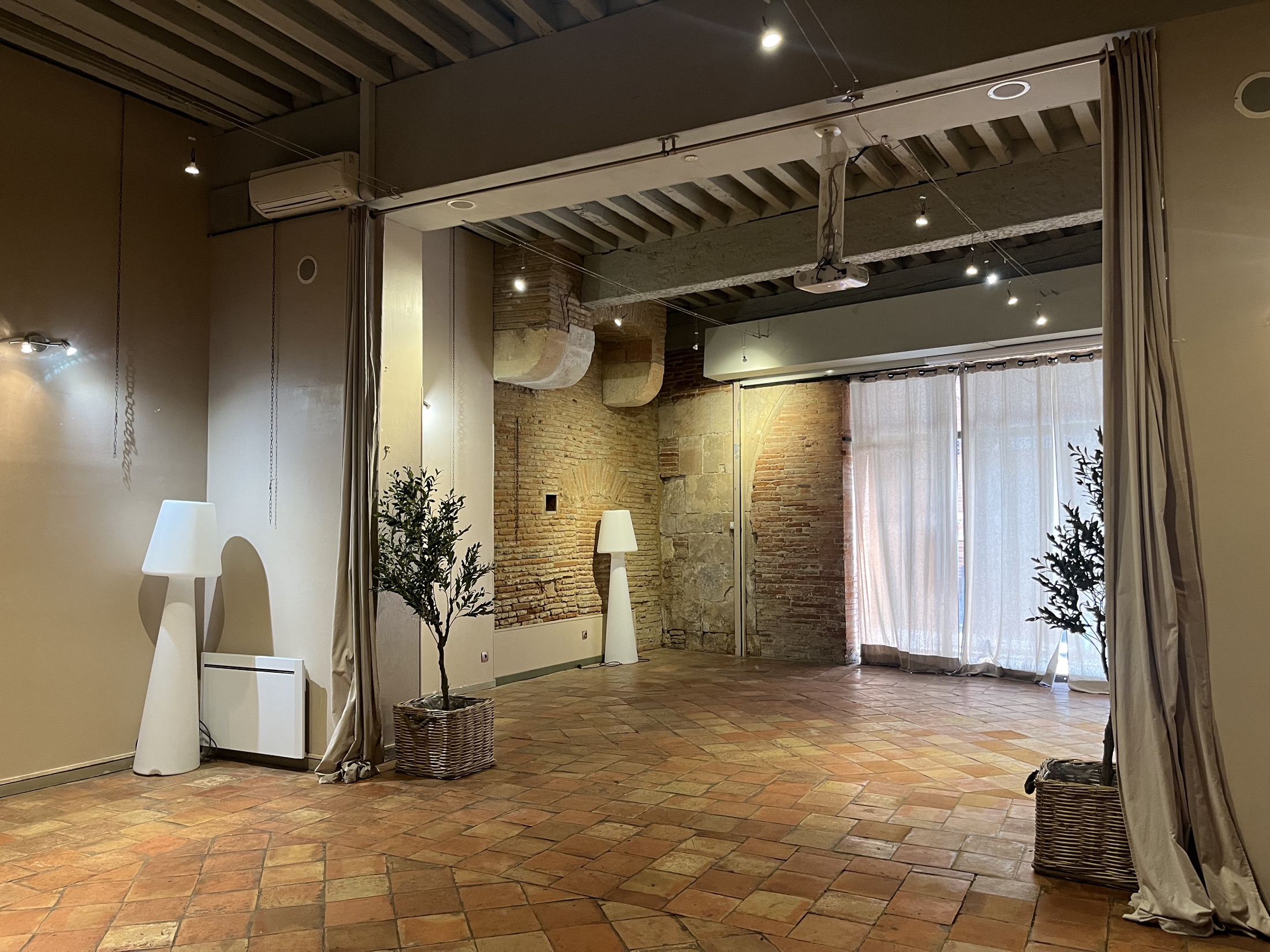 La salle vide, tomettes et murs de brique