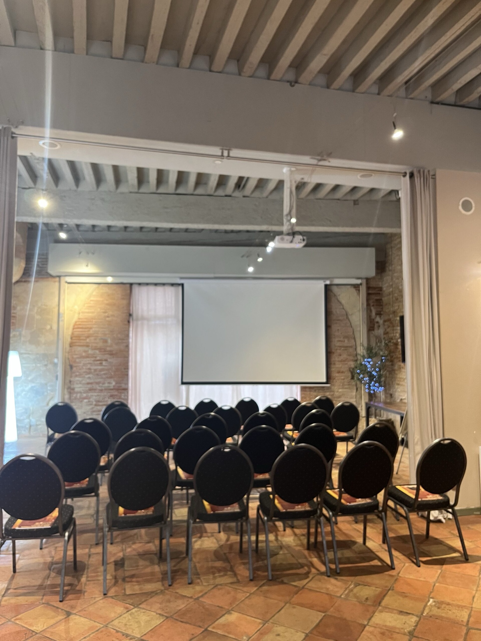 Salle configurée en conférence avec écran de projection